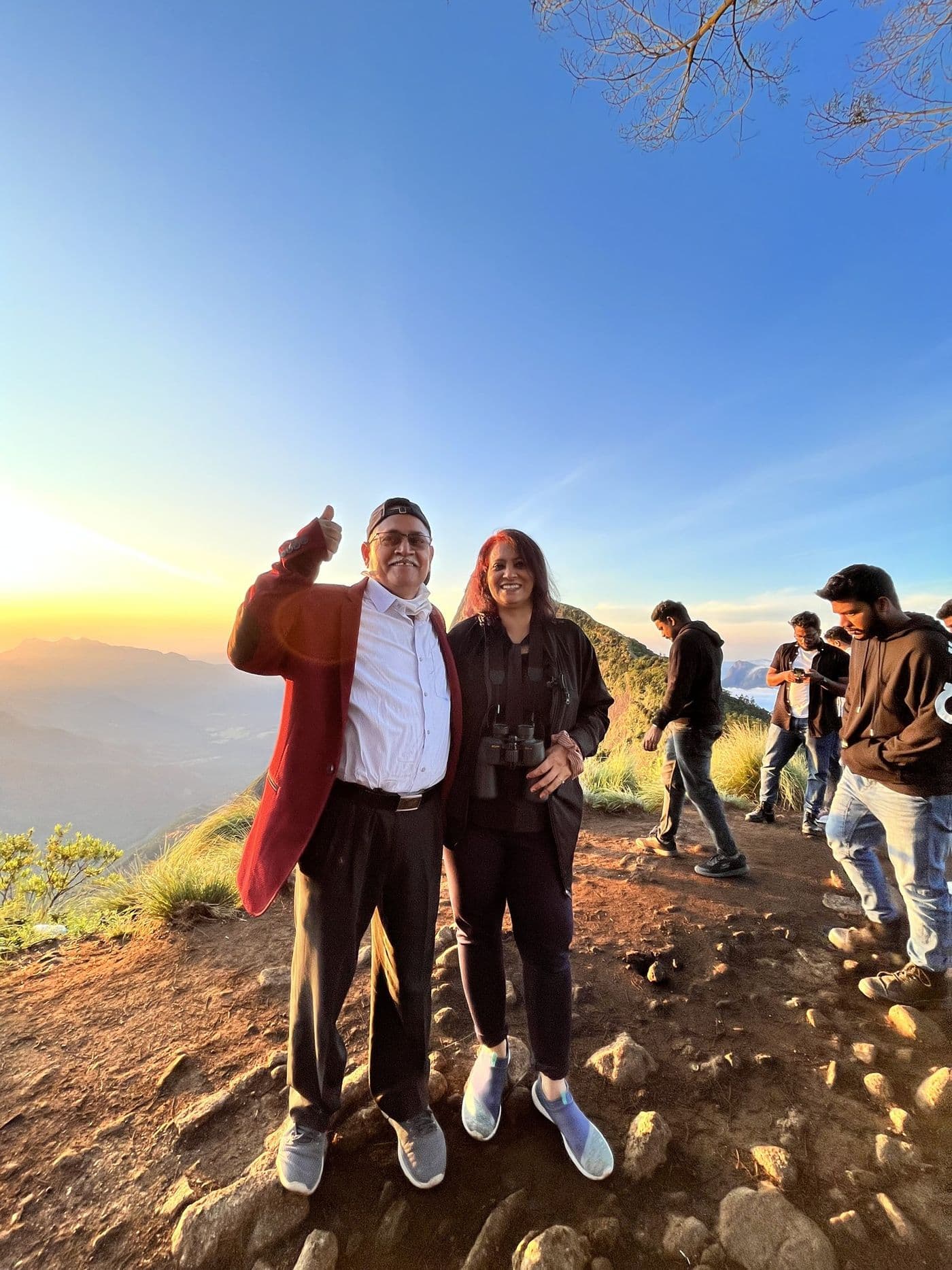 सूर्योदय के समय पहाड़ की चोटी पर, साथ खड़े हुए